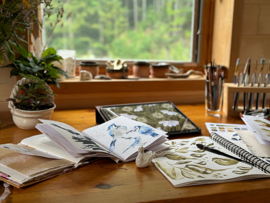 artist Bevin Marie's studio table with art on it